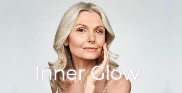 Woman with radiant skin touching her cheek with the words Inner Glow